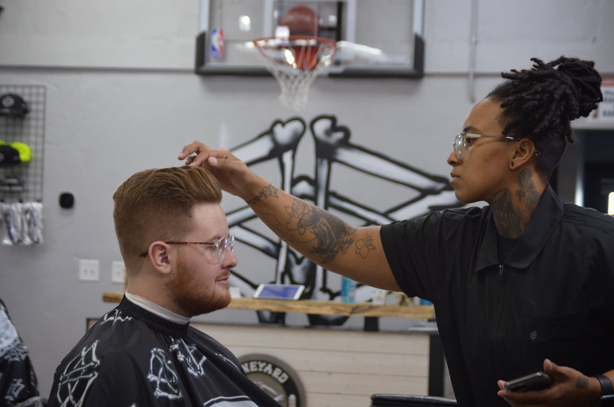 Boneyard barber cutting a client's hair in the shop
