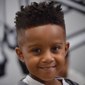 Curly top with fade on a young client at Boneyard Barbering