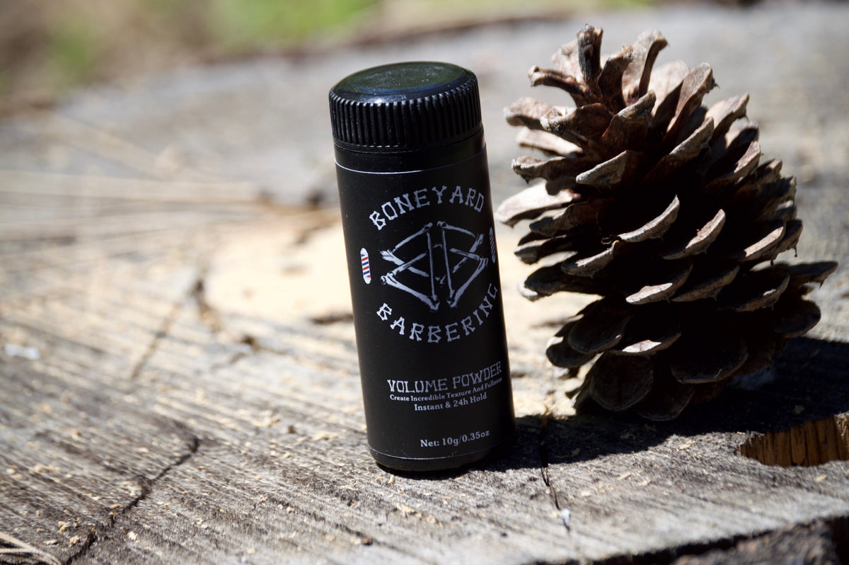 Boneyard Volume Powder bottle next to a pine cone
