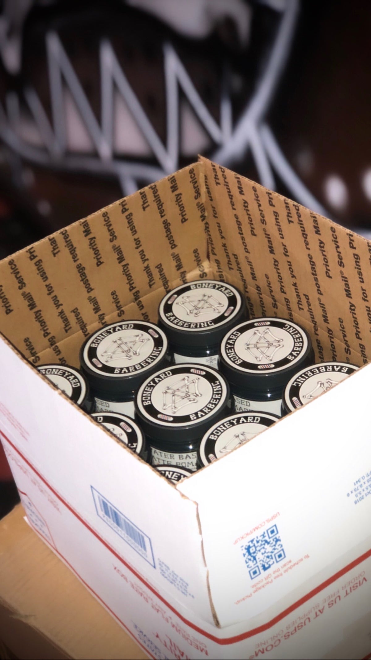 Case of Boneyard Matte Pomade jars in a shipping box