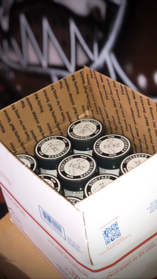 Case of Boneyard Matte Pomade jars in a shipping box