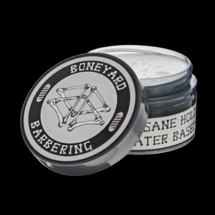 Open jar of Boneyard Matte Pomade on a black background